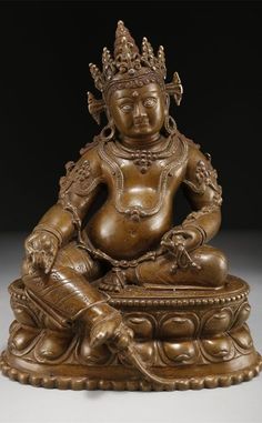 a bronze buddha statue sitting on top of a table