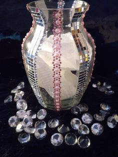 a glass vase sitting on top of a table next to some crystal stones and beads