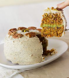 a person is holding a piece of cake on a plate with another slice missing from it