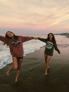 two girls running on the beach holding hands