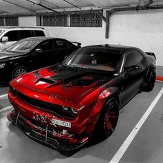 two cars parked in a parking garage with red and black paint splattered on them