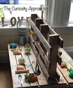 a wooden table with bowls and spoons on it, next to a window that says the curiosity approach