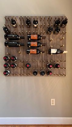 a wall mounted wine rack filled with lots of bottles on top of a wooden floor