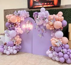 balloons are arranged in the shape of an arch with butterflies and flowers on it for a birthday party