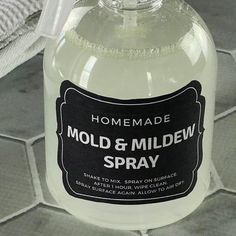 a bottle of homemade mold and mildew spray sitting on a tiled floor