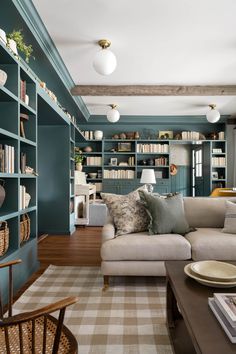 a living room filled with furniture and bookshelves covered in lots of bookcases