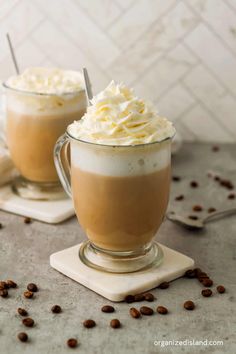 two mugs filled with whipped cream and coffee beans