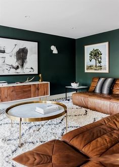 a living room with green walls and leather furniture