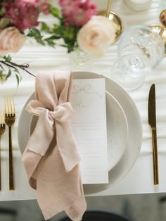 a place setting with napkins, silverware and flowers