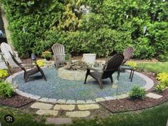 a circular patio with chairs around it in the middle of some grass and flowers on the ground