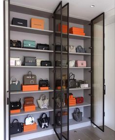 the closet is full of purses and handbags on display in it's glass doors