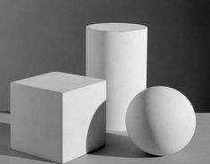 three white vases sitting on top of a table next to each other in front of a gray wall