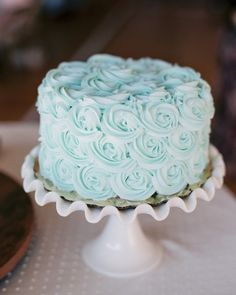 a blue frosted cake sitting on top of a table