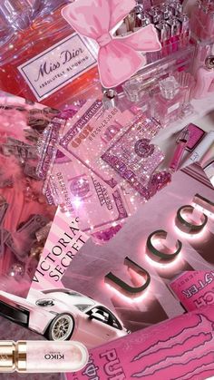 many pink items are scattered on top of each other in this image, including lipstick and perfume bottles