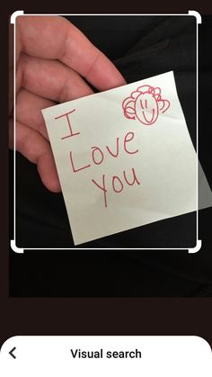 someone holding a note with the words i love you written on it