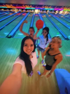 some girls are playing with a ball in a bowling alley