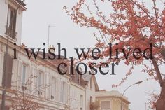 the words i wish we lived closer are displayed in front of some buildings and trees