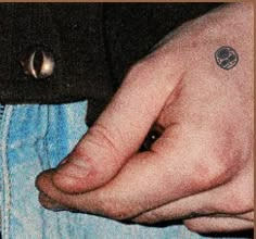 a person's hand with a small tattoo on it