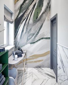 a bathroom with marble walls and flooring next to an open door that leads to another room