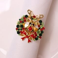 a napkin holder with a christmas wreath and bells on it, sitting on top of a white napkin