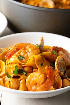 a white bowl filled with pasta and shrimp