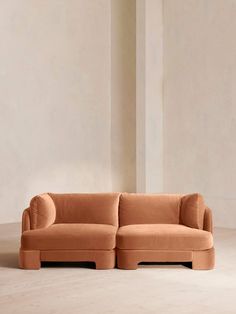 an orange couch sitting on top of a white floor