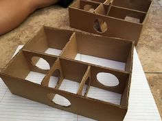 three cardboard boxes with holes in them sitting on top of a piece of paper