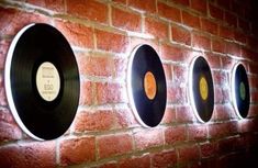 three records are mounted to the side of a brick wall