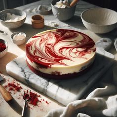 a cake sitting on top of a table covered in red and white swirled icing