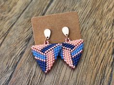 a pair of earrings sitting on top of a wooden table