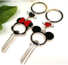 three mickey mouse keychains with red hearts on them, one is black and the other is white