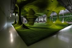 an art installation with green grass and trees