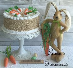 there is a cake with carrots on it and a rabbit figurine next to it