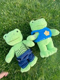 two stuffed animals are laying in the grass