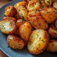 a blue plate topped with cooked potatoes covered in parmesan cheese and seasoning