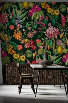 a table and chairs in front of a floral wallpaper