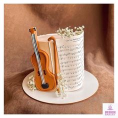 a violin cake with sheet music and flowers on the top is ready to be eaten