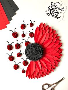 paper flowers and scissors on a table with crafting supplies for making ladybugs