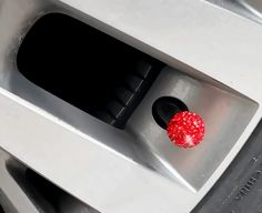 a close up of a red object on the side of a silver car door handle