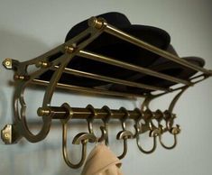 a hat and coat rack with hats hanging from it's hooks on the wall