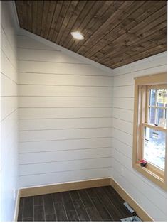 an empty room with wood flooring and white paint on the walls, along with two windows