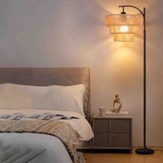 a bedroom with a bed, nightstand and lamp