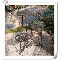 two metal tables sitting on top of gravel