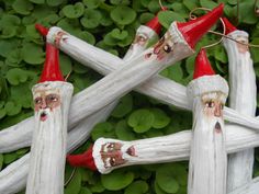 several white and red wooden sticks with faces painted on them in the shape of santa claus