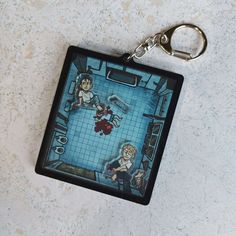 a keychain with an image of two people in a bathroom on the floor