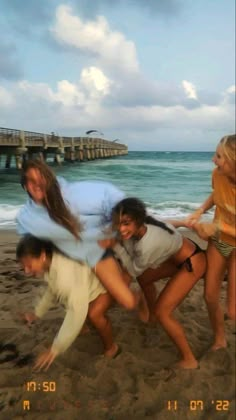 four people on the beach posing for a photo