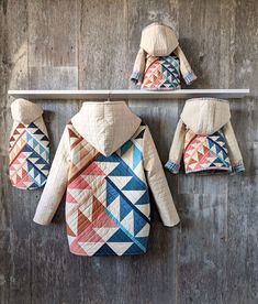 three jackets hanging on the wall, one with a quilted pattern and two without