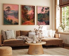 three paintings hang on the wall above a couch in a living room with a coffee table