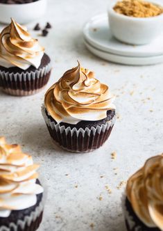 several cupcakes with frosting and peanut butter on top are sitting on a table