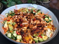 a salad with chicken, cucumbers and carrots